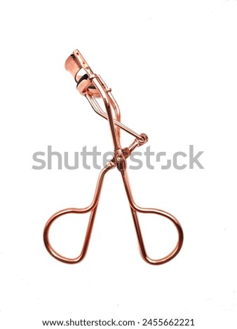 Top view of a metallic eyelash curler, isolated on white background.