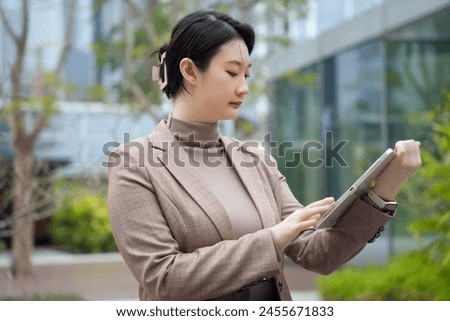 Professional Woman Engaging with Tablet Outside Office