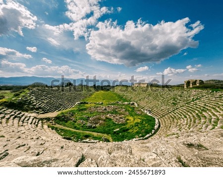 The Aphrodisias Stadium, set against a backdrop of clouds and sky, stands as a testament to Turkey's Greco-Roman heritage and history. Royalty-Free Stock Photo #2455671893