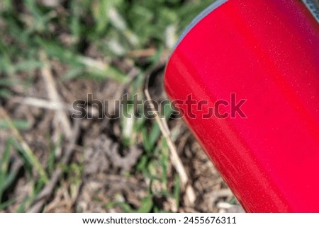 Recycling object. The Saga of the Red Can. Empty space to write something.  Thrown away in the park. Save the nature, concept. Royalty-Free Stock Photo #2455676311