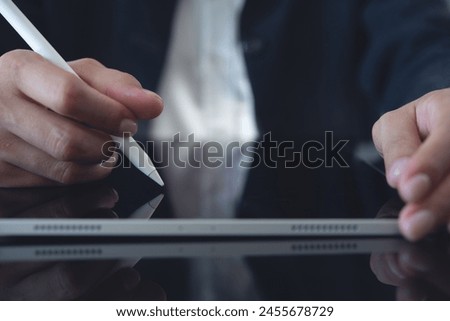 Close up of business woman using stylus pen signing business contract on digital tablet via mobile app, e-signing, electronic signature concept. Businesswoman proofing e-document at office