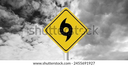 Hurricane Idalia warning sign against a powerful stormy background with copy space. Dirty and angled sign with cyclonic winds add to the drama.hurricane season sign on cloudy background Royalty-Free Stock Photo #2455691927