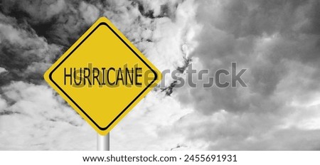 Hurricane Idalia warning sign against a powerful stormy background with copy space. Dirty and angled sign with cyclonic winds add to the drama.hurricane season sign on cloudy background Royalty-Free Stock Photo #2455691931