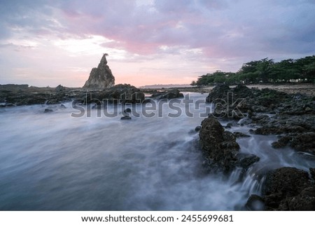 seascape is very beautiful with coral rocks and sea water that looks very soft like cotton at Sawarna Beach, Indonesia. slow shutter speed effect