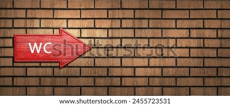 Red wooden shooter sign with the inscription WC hangs on a dark brick wall. Right arrow pointer. Direction indicator
