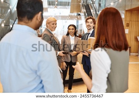 Multicultural business team collaborate in stylish lobby setting. Royalty-Free Stock Photo #2455736467