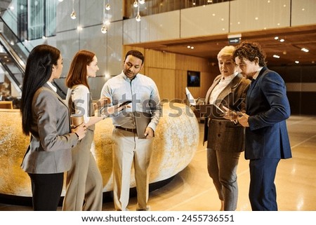 Multicultural professionals engaged in discussion in a lobby. Royalty-Free Stock Photo #2455736551