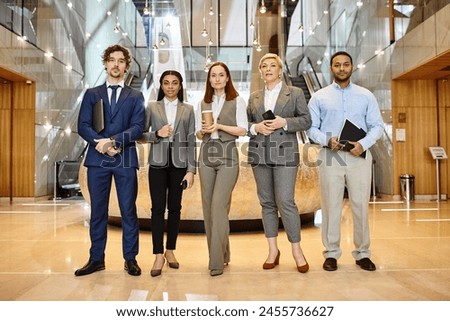 Multicultural business professionals collaborating in modern lobby setting. Royalty-Free Stock Photo #2455736627