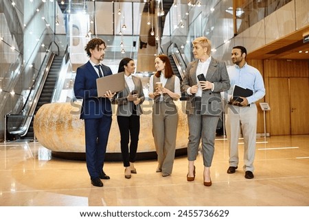Multicultural business professionals gather in a sleek and contemporary lobby. Royalty-Free Stock Photo #2455736629