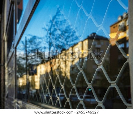 A close up of a window with reflections of buildings
