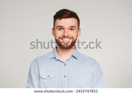 Portrait of smiling millenial guy on beige background, panorama, copy space