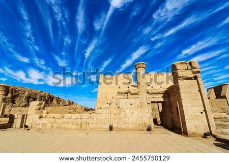 Beautiful bright blue skies and wispy cloud patterns over the atmospheric temple of Kom Ombo dedicated to crocodile goddess Sobek and Haroeris built by Ptolemy pharoahs in Kom Ombo,Near Aswan,Egypt Royalty-Free Stock Photo #2455750129
