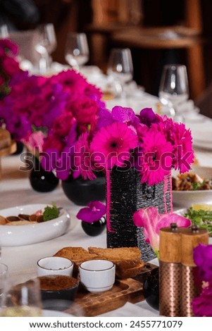 
Table setting at a holiday with a large number of people at the table. Red flowers for the holiday