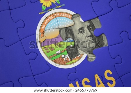 puzzle with the colourful national flag of kansas state and usa dollar banknote. finance concept
