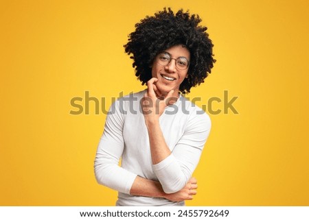 Young african american man smiling on orange studio background. Lucky person.