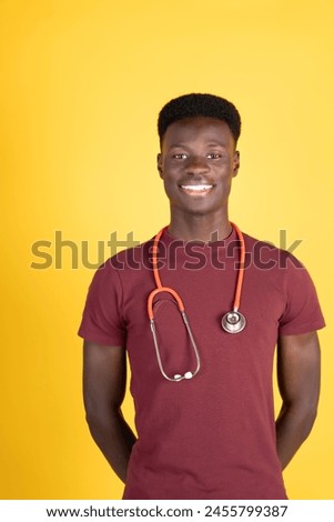 A young man wearing a red shirt and a red stethoscope is smiling. He is posing for a picture