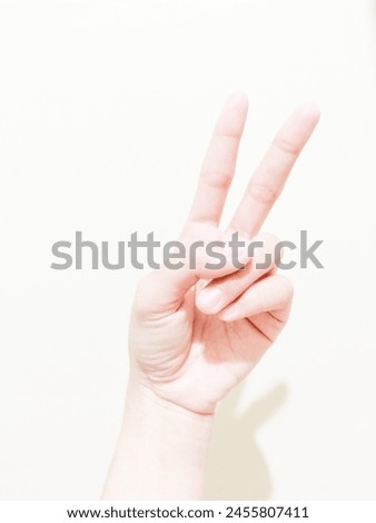 Finger showing the number two on a plain background