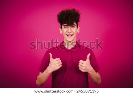 Funny emotional student posing in studio against color background.