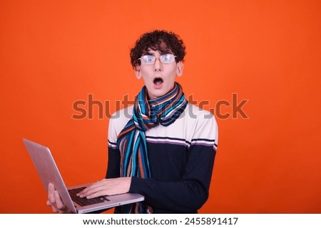 Funny emotional student posing in studio against color background.