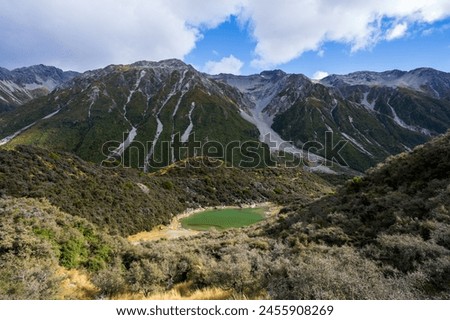 Small green lake in cloudy mountains, Blue Lake, Tasman Glacier, New Zealand