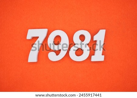 The number 7981 is made from white painted wood placed on a background of orange paper.