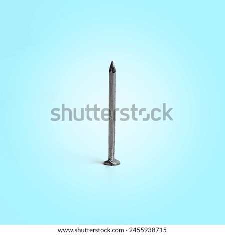 One Silver Shiny Sharp Metal Nail Closeup Photo Of Sharp Metal Nail Standing On Soft Blue Background