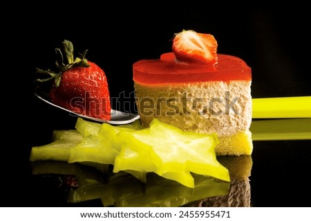heart shaped strawberry cake with carambola or star fruit decoration over black background
