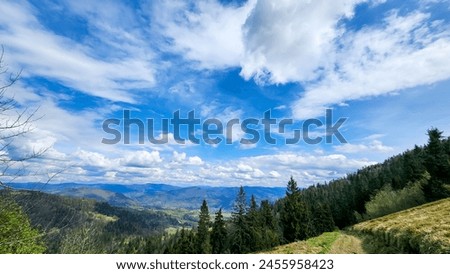 Breathtaking panoramic view of a serene valley, nestled amidst rolling mountains under a majestic sky. Ideal for travel, nature themes, and inspirational content