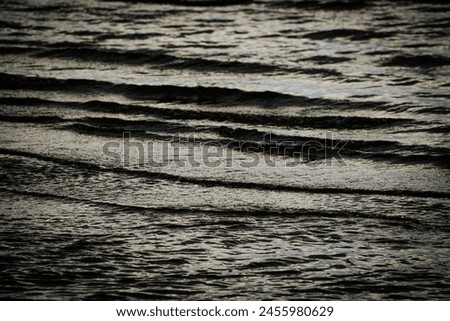 Dark ominous sea water with waves. Soft selective focus. Artificially created grain for the picture