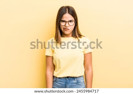 pretty hispanic woman feeling confused and doubtful, wondering or trying to choose or make a decision