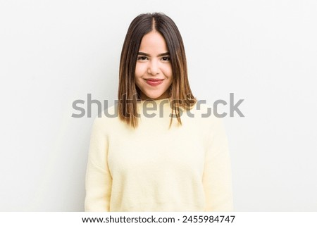 pretty hispanic woman smiling positively and confidently, looking satisfied, friendly and happy