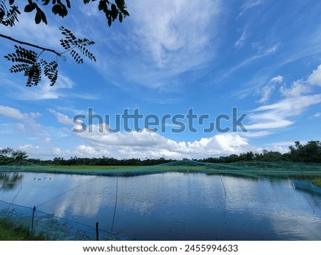 Blue Sky with white clouds, fisheries,lots of trees,green fields.