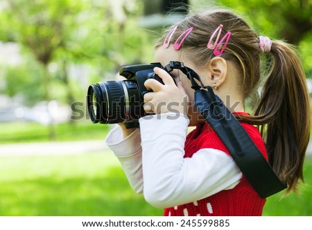 Girl who takes pictures with a photo camera in park