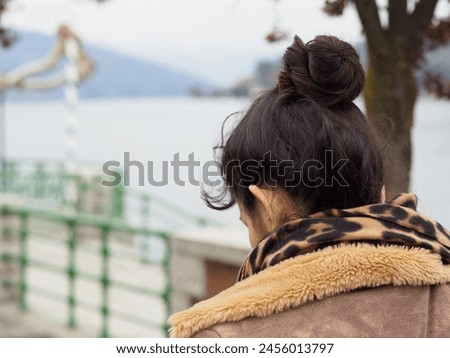 hispanic woman walking lakeside in winter time travel concept