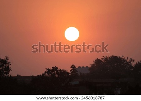 As the sun sinks lower, the colors intensify, reaching a crescendo of fiery brilliance before gradually fading into the deepening shades of twilight.  Royalty-Free Stock Photo #2456018787