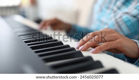 Close-up of female hands playing synthesizer in music workshop. Professional cute pianist creating new musical composition. Art concept. Blurred background Royalty-Free Stock Photo #2456025077