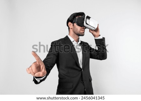 Smart manager looking at data by using VR goggle while pointing at data analysis. Caucasian investor connect metaverse while wearing suit and virtual reality headset. Innovation technology. Deviation.