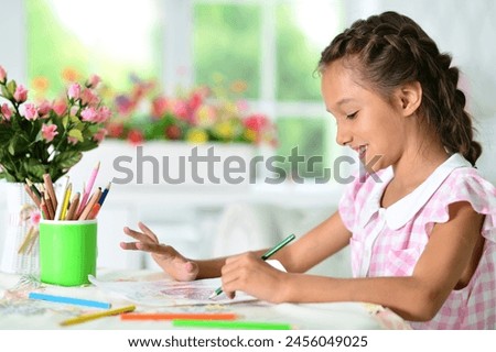 Portrait of cute little girl drawing picture at home. High quality photo