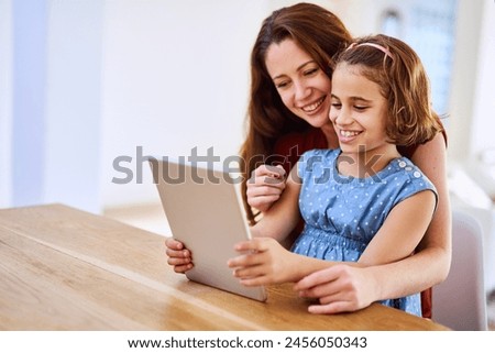 Mother, girl and tablet for bonding at table, online play and remote learning or education in home. Daughter, mama and website for cartoon or games for development, love and support in childhood