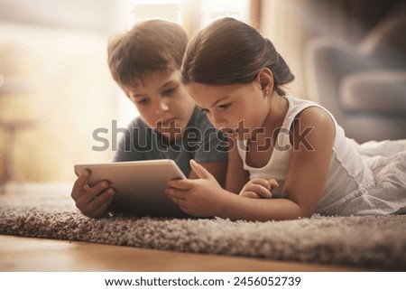 Children, video and watching with tablet on floor for digital education, ebook and learning in house. Boy, girl and tech on ground for cartoon, kids story and movie or virtual gaming app in home