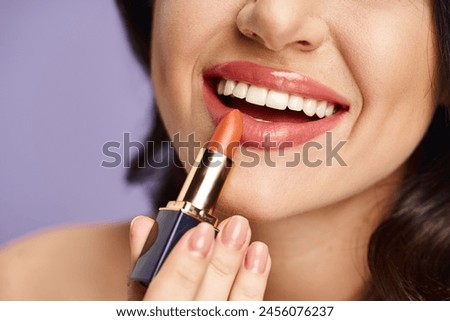 A beautiful woman enhancing her appearance by applying lipstick to her lips.