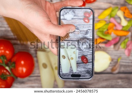 op view of taking photos with a smartphone of a table with ingredients for spaghetti