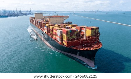 Aerial side view of cargo ship with contrail in the ocean sea ship carrying container and running from container international port smart freight shipping by ship service.