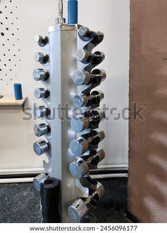 dumbbells with different weights on a rack in the gym