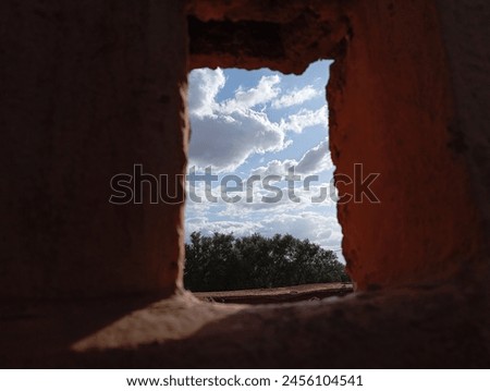 A picture through a small window of the blue sky filled with white clouds, like a window overlooking heaven, a good quality picture 