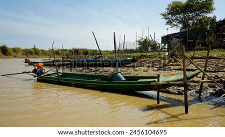 traditional wooden boat on the tonle sap river in cambodia Royalty-Free Stock Photo #2456104695