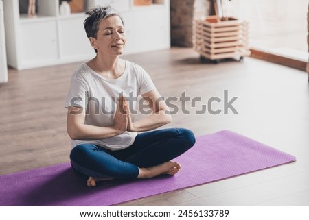 Full size photo of nice retired woman meditate lotus pose sportswear sport healthy lifestyle workout modern apartment home living room