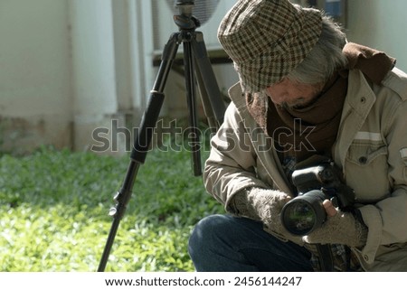 A man with a camera is taking a photo of something on the ground.