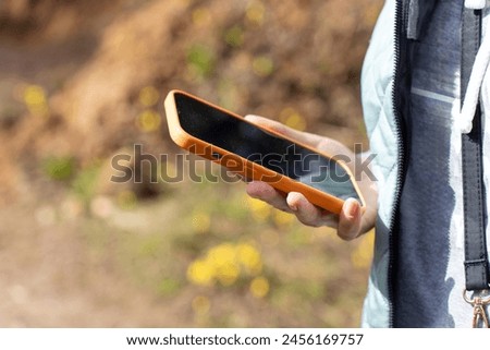smartphone in the hand of a woman in the park. High quality photo