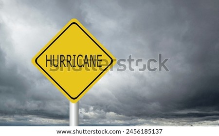Hurricane Idalia warning sign against a powerful stormy background with copy space. Dirty and angled sign with cyclonic winds add to the drama.hurricane season sign on cloudy background Royalty-Free Stock Photo #2456185137